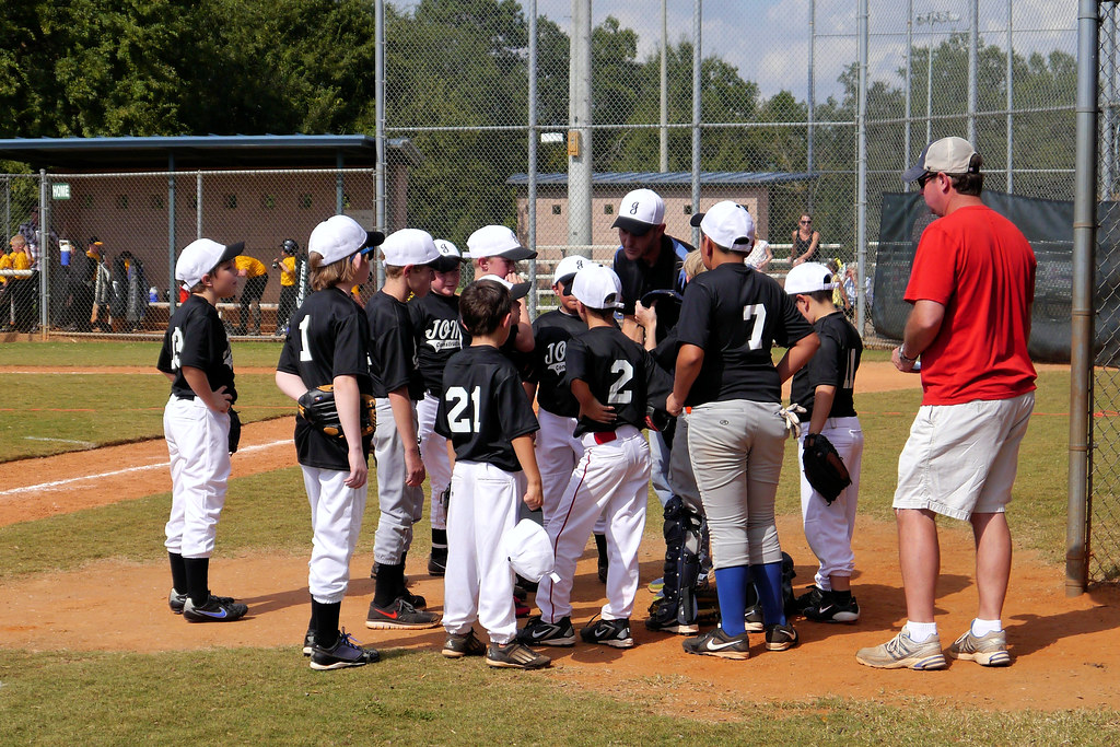 Coach talking through tactics with junior players around him