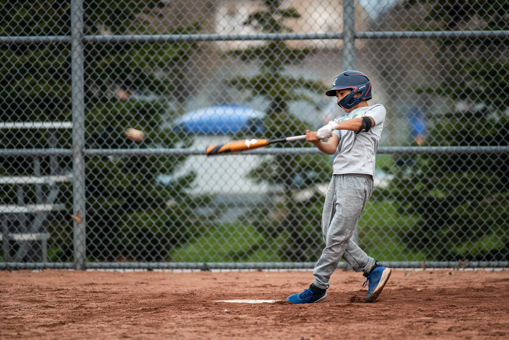 Player mid-swing during a filmed hitting assessment